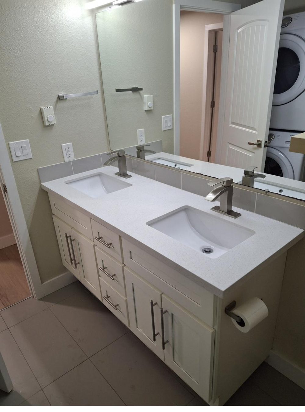 Renovated bathroom with double vanity and quartz countertop