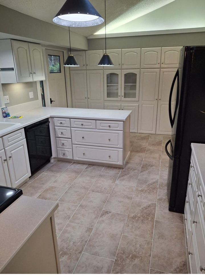 Kitchen remodel with white cabinets, island and tile flooring