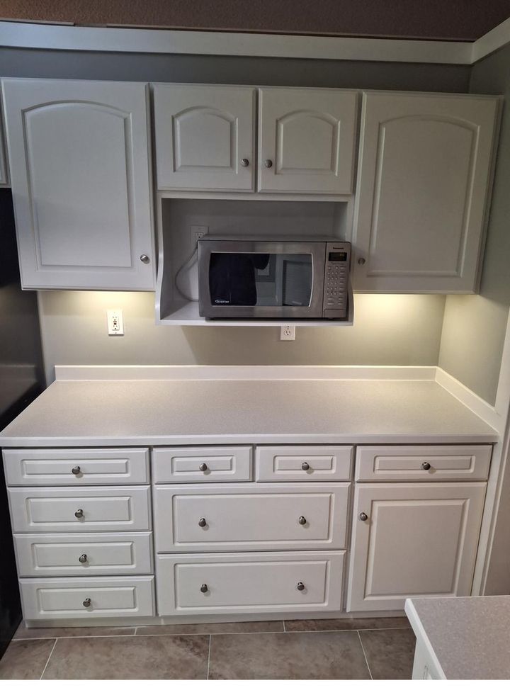 Modern kitchen with built-in microwave and white cabinetry